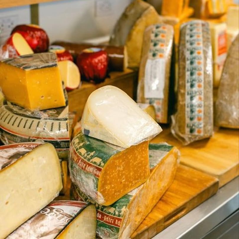 Assorted cheeses, including large wheels and wedges, displayed on wooden boards at The Cheese Store of Beverly Hills.