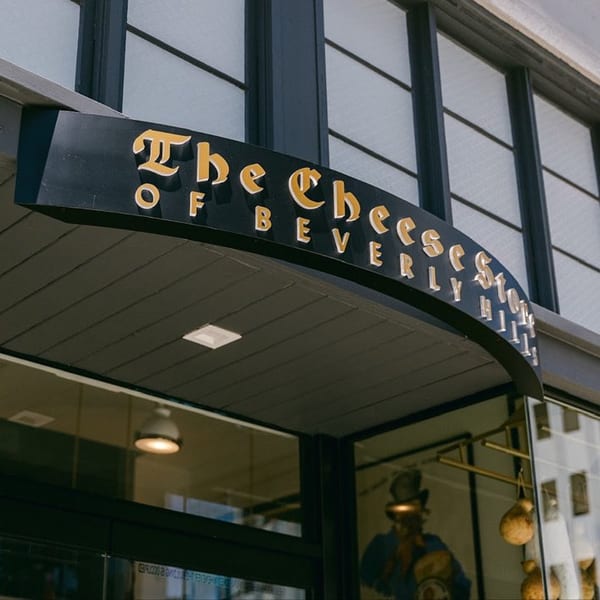 The Cheese Store of Beverly Hills sign, a black curved awning with gold lettering.