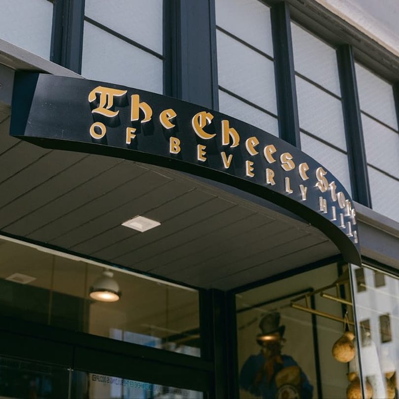 The Cheese Store of Beverly Hills sign, a black curved awning with gold lettering.